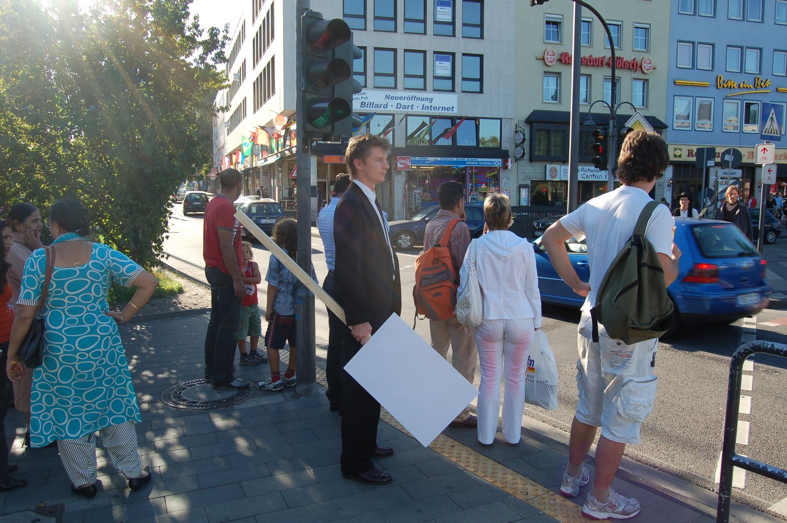The suited figure with the sign at a crossing