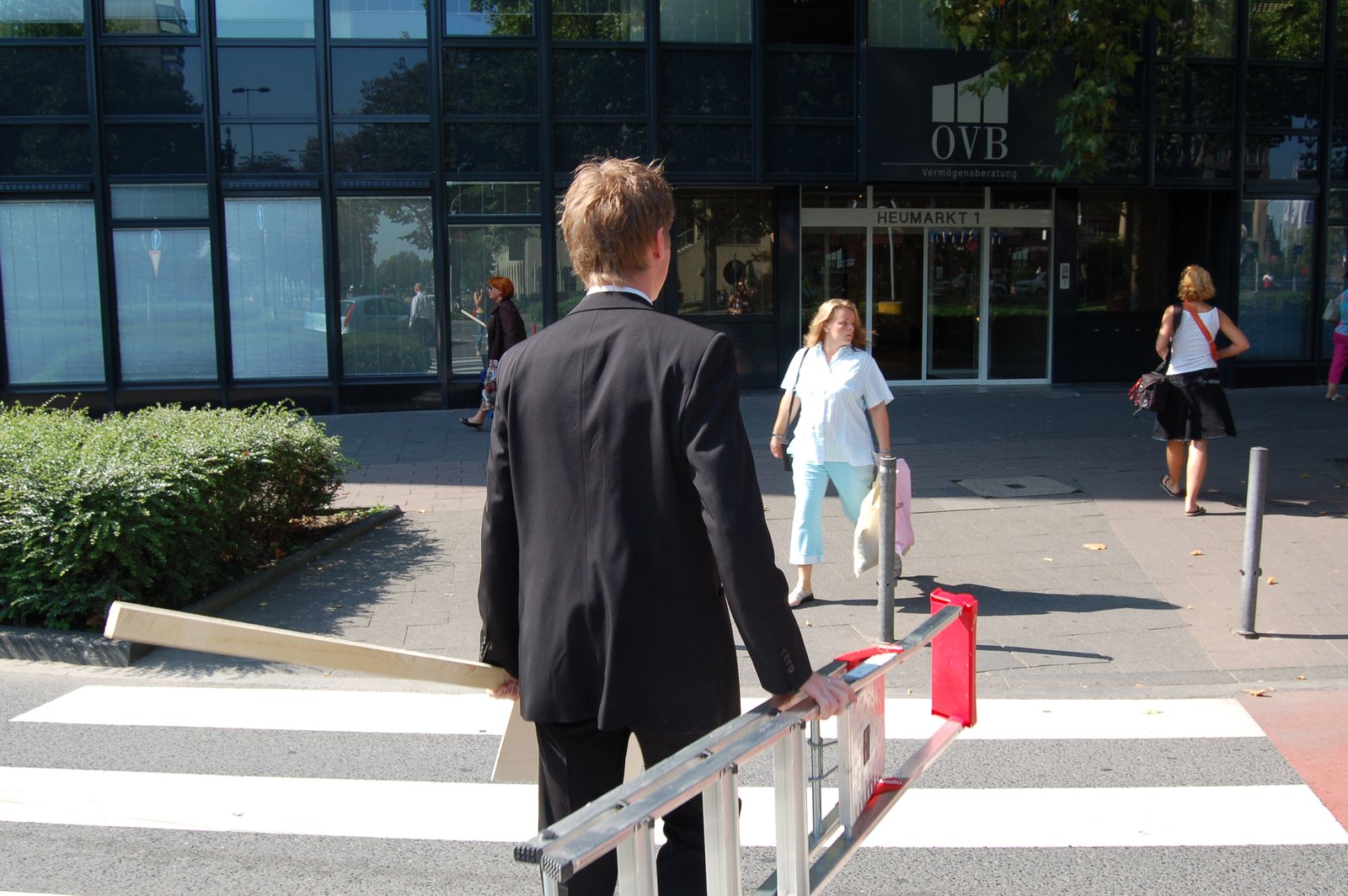 The performer with the sign crossing the street